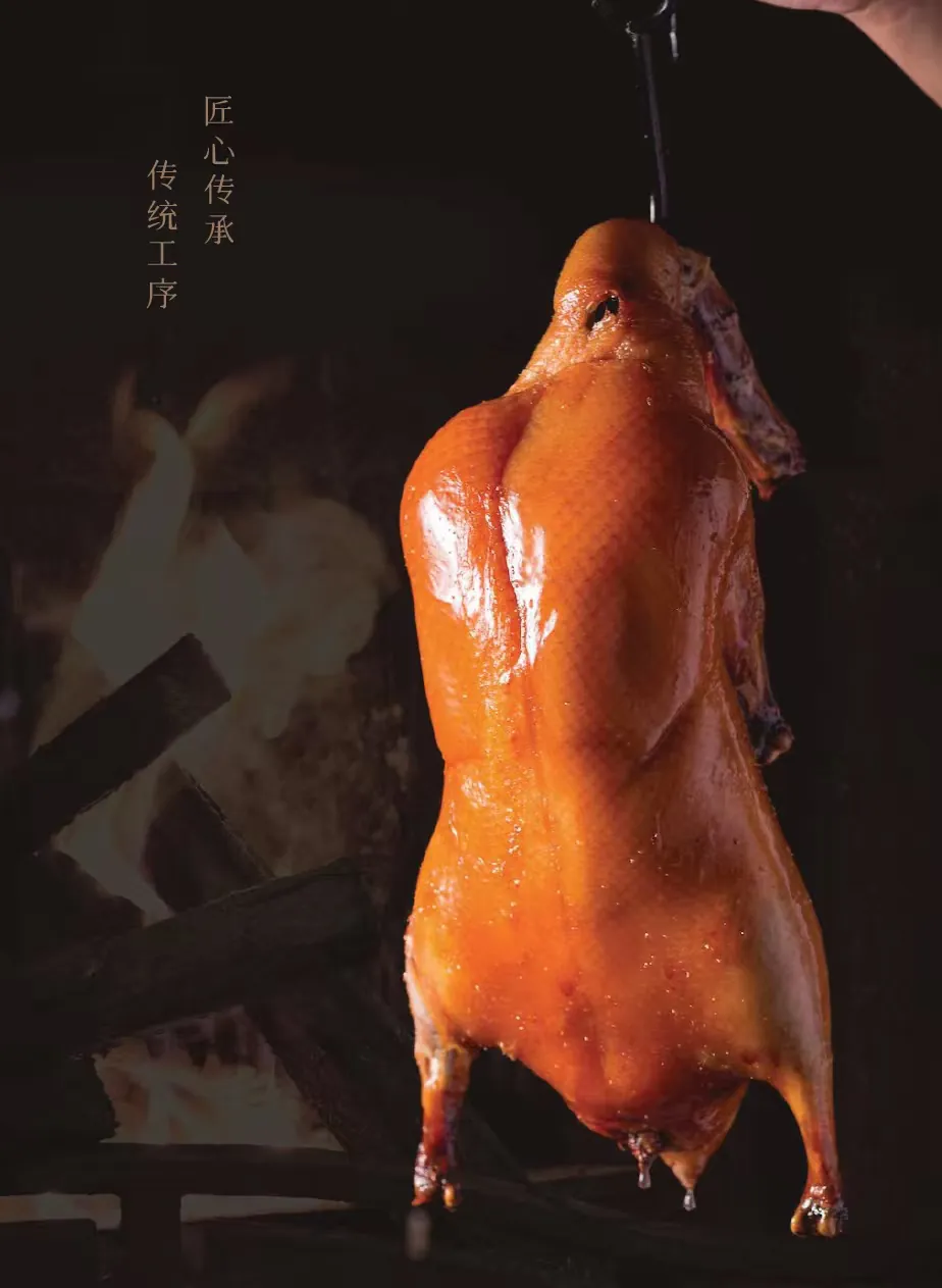 A whole duck hanging above a wood fire in the duck oven
