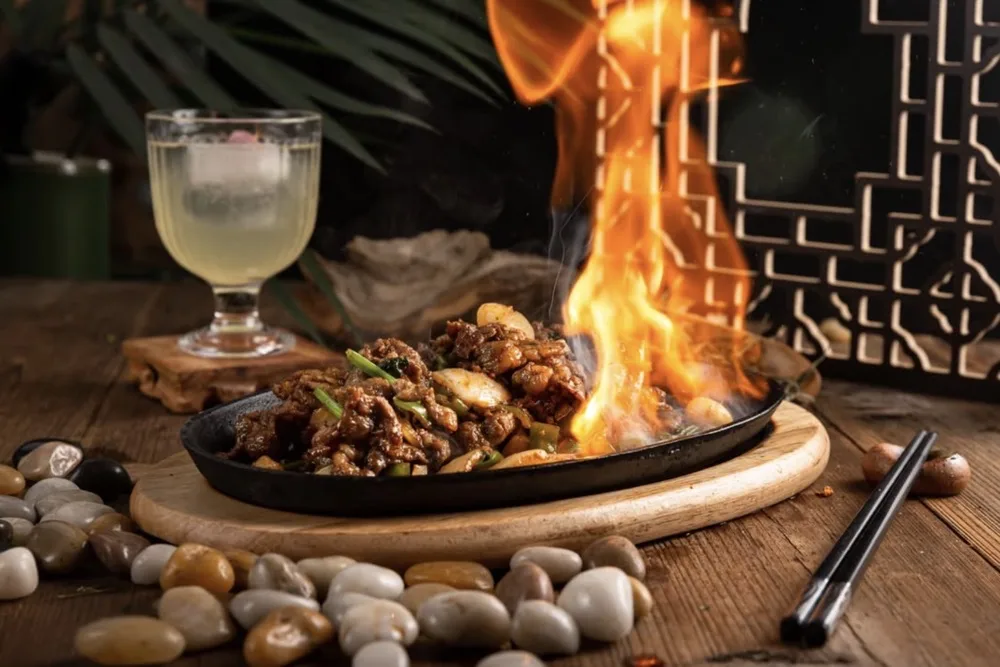 Cumin lamb served sizzling with open flame