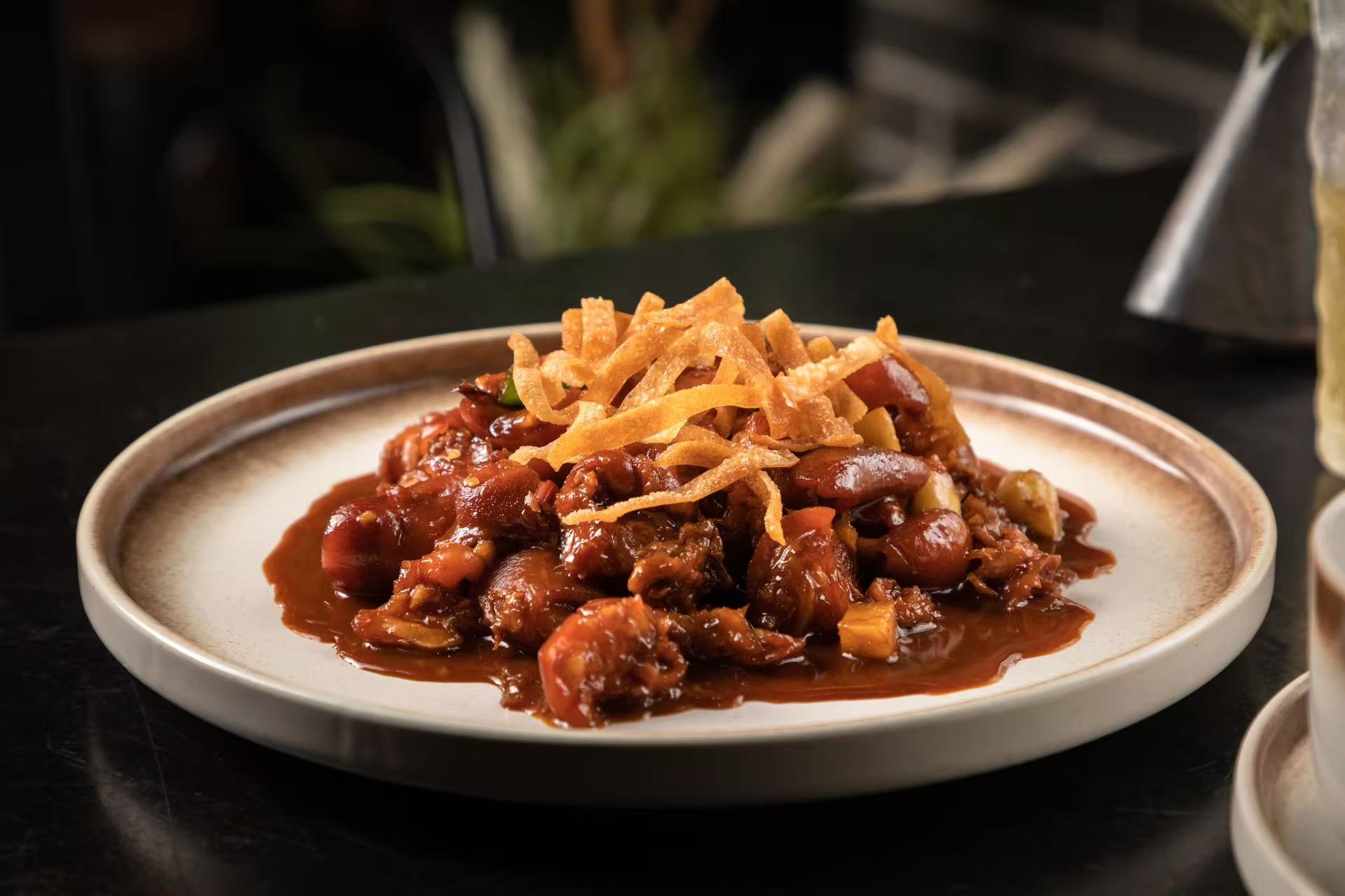 Spicy boneless pig trotters in a rich sauce on a white plate