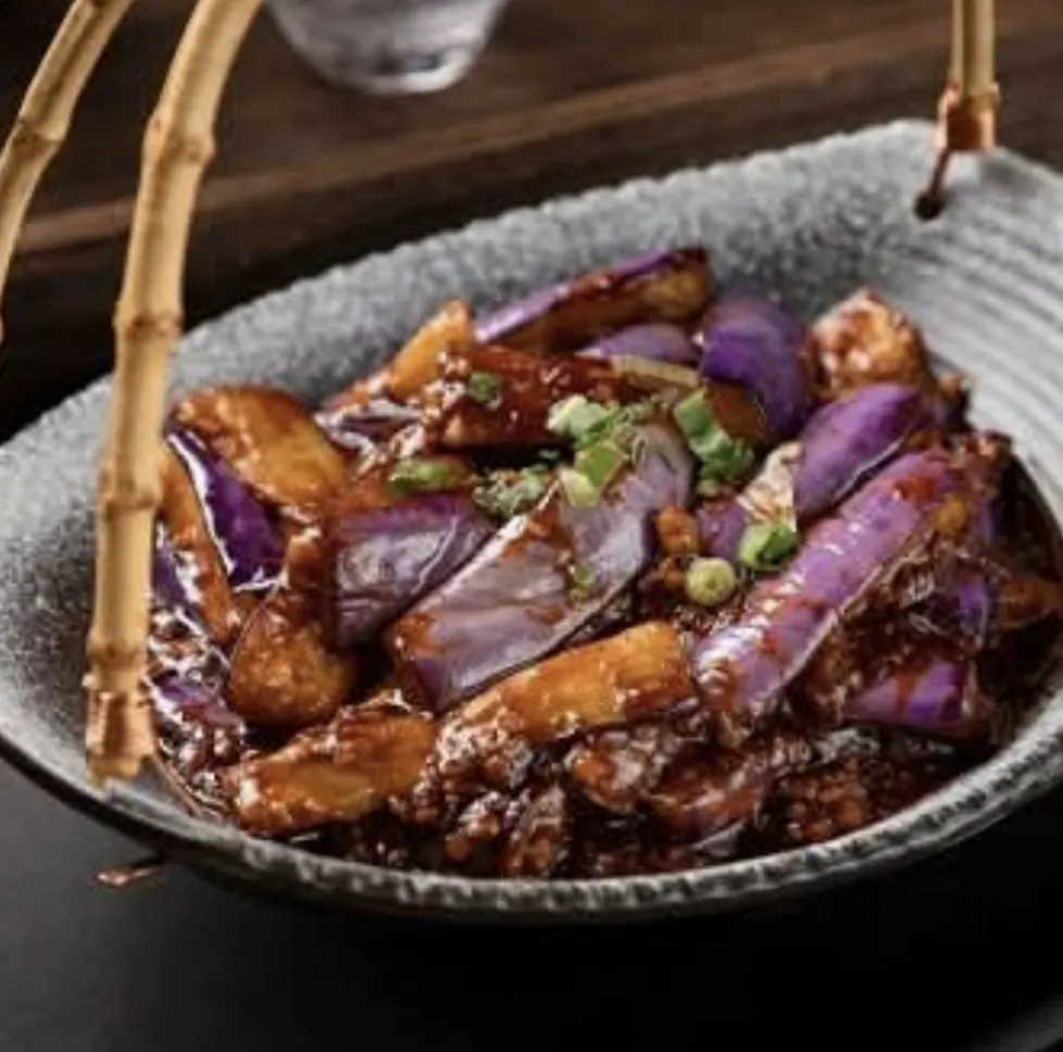 A vegetable dish in a ceramic bowl with warm lacquer lighting